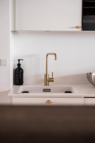 a kitchen sink with a faucet on it at The Nyhavn Penthouse by Daniel&Jacob's in Copenhagen