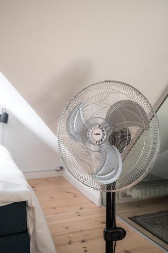 a white fan sitting in a room next to a bed at The Nyhavn Penthouse by Daniel&Jacob's in Copenhagen
