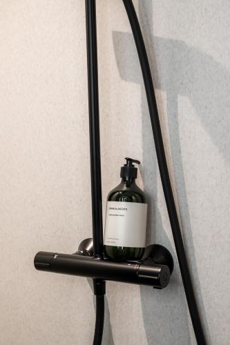 a bottle of soap in a holder on a wall at The Nyhavn Penthouse by Daniel&Jacob's in Copenhagen