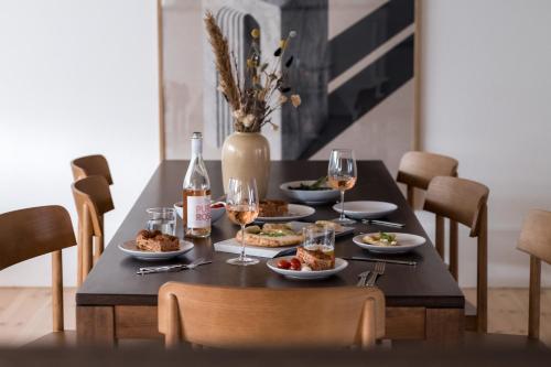 a table with plates of food and glasses of wine at The Nyhavn Penthouse by Daniel&Jacob's in Copenhagen