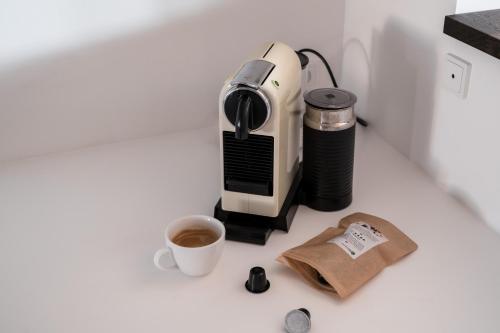 a coffee maker and a cup of coffee on a counter at The Nyhavn Penthouse by Daniel&Jacob's in Copenhagen