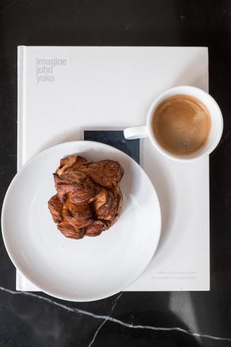 a plate with a cup of coffee and a pastry at The Nyhavn Penthouse by Daniel&Jacob's in Copenhagen