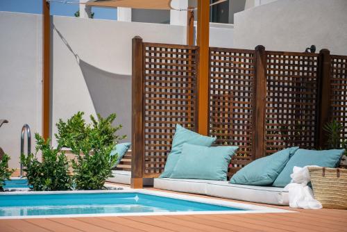 a patio with a couch next to a swimming pool at Dolce by Wyndham Athens Attica Riviera in Vravrona