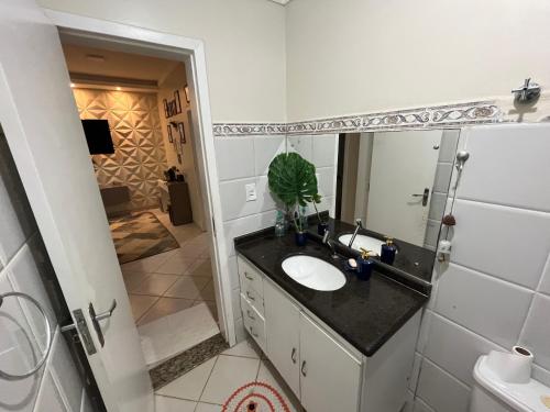 uma casa de banho com um lavatório, um espelho e um chuveiro em Apartamento completo e elegante, BEM LOCALIZADO. em Porto Velho