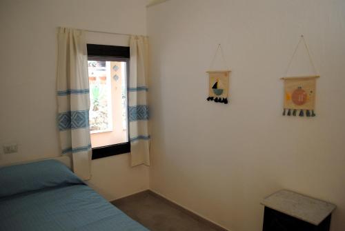 a bedroom with a bed and a window at Cala Sinzias beach house with stunning views in Costa Rei