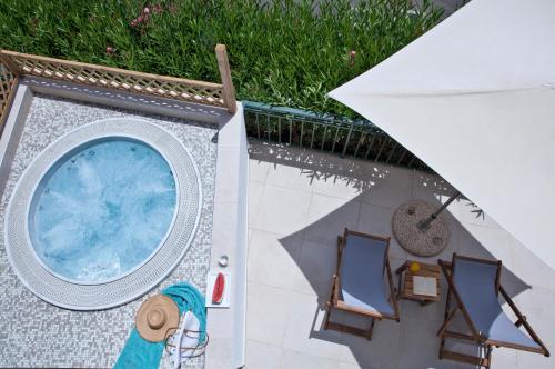 an overhead view of a pool with chairs and an umbrella at Dolce by Wyndham Athens Attica Riviera in Vravrona