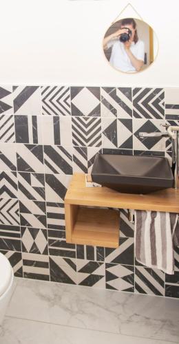 une personne prenant une photo d'une salle de bains avec un miroir dans l'établissement Villa moderne avec piscine, à Albi