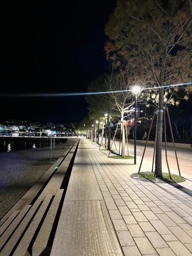 a street at night with benches and lights at Electra The Seaside Apartments in Sarandë