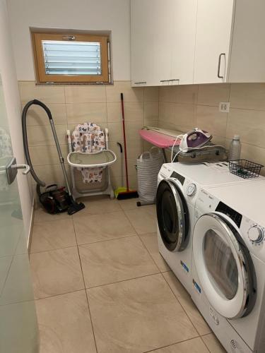 a laundry room with a washing machine in it at Capo House in Gračišče