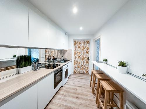 Il comprend une cuisine avec des placards blancs et du parquet. dans l'établissement Le 16 - Charmant appartement proche du centre ville, à Strasbourg