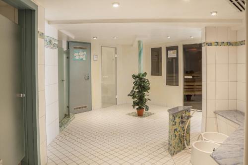 un couloir d'une salle de bains avec une plante en pot dans l'établissement Hotel Schwarzwald Freudenstadt, à Freudenstadt