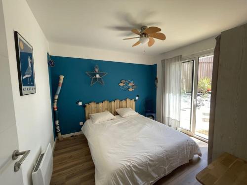 une chambre avec un lit et un ventilateur de plafond dans l'établissement Villa Les Pins, terrasse, piscine et jardin clôt, vue forêt, à Mimizan