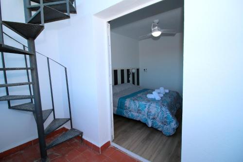 a bedroom with a bed and a spiral staircase at Duplex Mojácar Beach in Mojácar