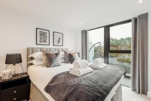 een slaapkamer met een groot bed en handdoeken bij Aurora South in Poole