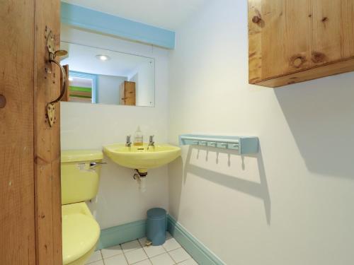 a bathroom with a yellow toilet and a sink at Gowanlea in Ambleside