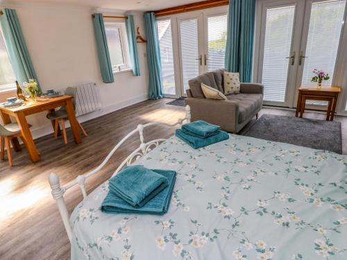 ein Wohnzimmer mit einem Bett und einer Couch in der Unterkunft Tower Cottage in Pembroke