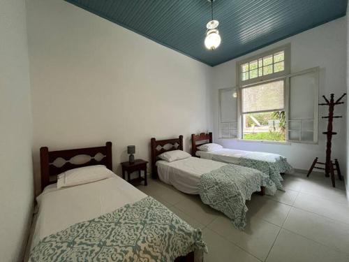 Natureza. Condominio 50m de SP في إتابيسيريكا دا سيرا: غرفة نوم بسريرين ونافذة