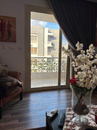 a living room with a vase of flowers on a table at شقه فاخره بكمبوندبشارع التسعين القاهره الجديده in New cairo