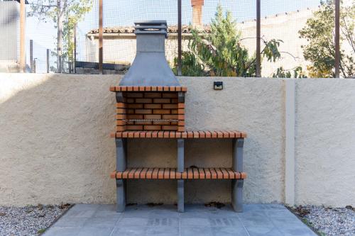 a structure sitting on a bench next to a wall at Cozy house in Priorat! Barbecue & Relax - Climbing & Views in Poboleda