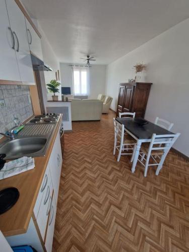 une cuisine et un salon avec une table et des chaises dans l'établissement Appartement Comme à la maison, à Le Breuil