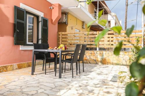 une table et des chaises sur le patio d'une maison dans l'établissement Sol Apartments Corfu by Estia, à Corfou