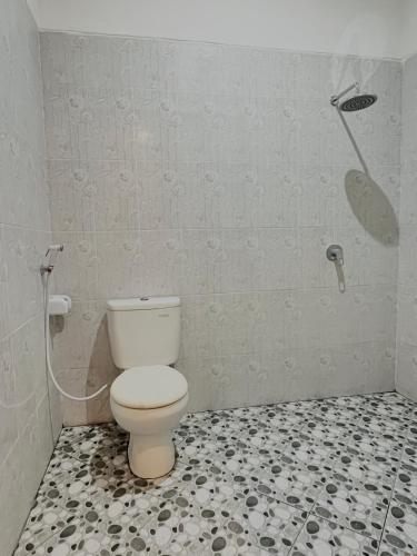 a bathroom with a toilet and a shower at Pondok Raamshanti Lembongan in Nusa Lembongan