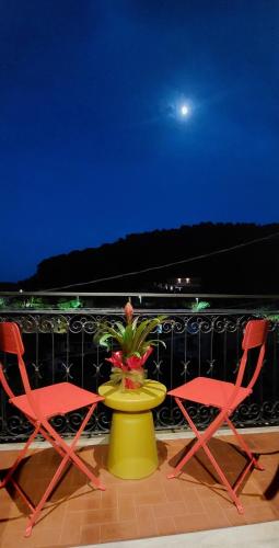 two chairs and a yellow table with a plant on it at Moderno appartamento vista mare, con parcheggio privato in Portovenere