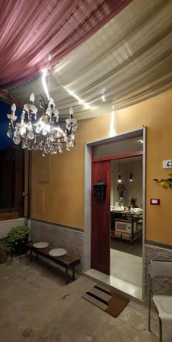 a living room with a chandelier and a kitchen at Moderno appartamento vista mare, con parcheggio privato in Portovenere