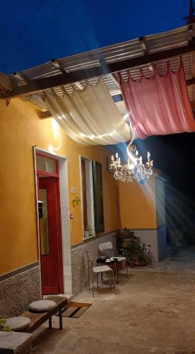 a patio with a table and chairs and a chandelier at Moderno appartamento vista mare, con parcheggio privato in Portovenere
