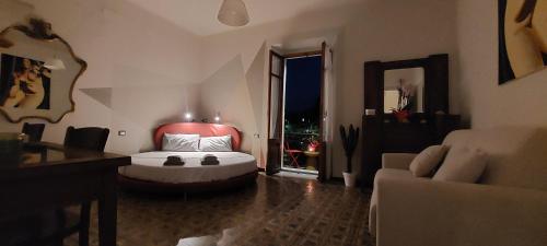 a bedroom with a bed and a couch and a window at Moderno appartamento vista mare, con parcheggio privato in Portovenere