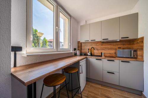 una cocina con armarios blancos y una barra con taburetes en Hotel Gromada Poznań en Poznan