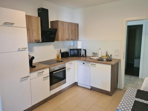 a kitchen with white cabinets and a stove top oven at peter@home in Sipbachzell
