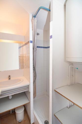 - deux vues sur une salle de bains pourvue d'une douche et d'un lavabo dans l'établissement Vacancéole - Résidence Samaria Village - Hacienda Beach, au Cap d'Agde