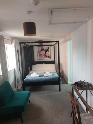 a bedroom with a bed and a green couch at Pilgrims of the Goddess in Glastonbury