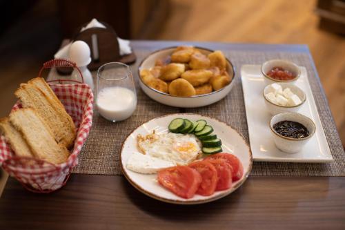 a table topped with plates of breakfast foods and milk at Vista Boutique Hotel in Berat