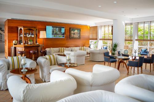 a living room with white chairs and tables at Melia Cala d'Or Boutique Hotel in Cala d´Or