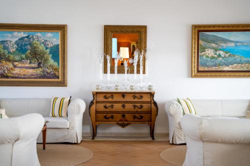 a living room with two white chairs and a dresser at Melia Cala d'Or Boutique Hotel in Cala d´Or