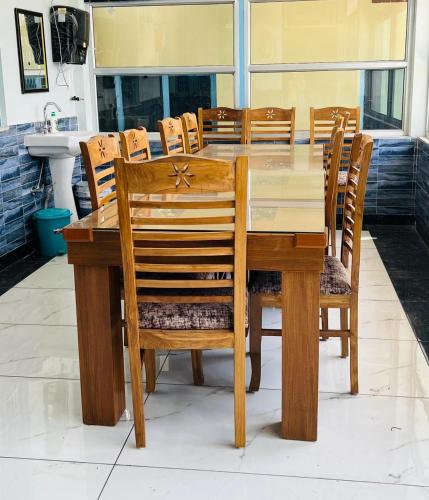a wooden dining room table with chairs and a sink at PINAK HOMESTAY in Almora