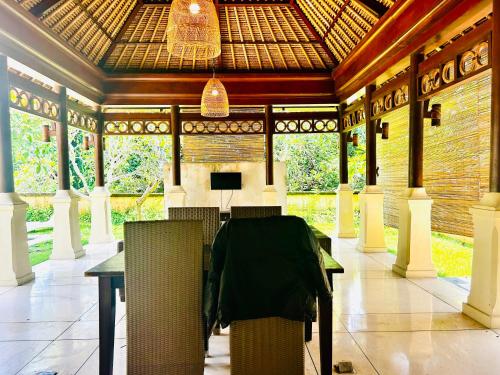 a room with a table and chairs in a building at Jimbaran Cozy Stay in Jimbaran