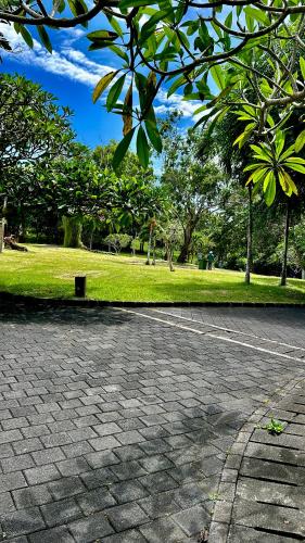a parking lot with a park with trees and grass at Jimbaran Cozy Stay in Jimbaran
