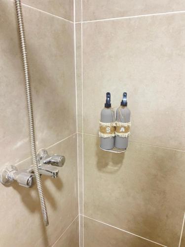 dos botellas de agua están sentadas en una ducha en GMP suites en San Miguel de Tucumán