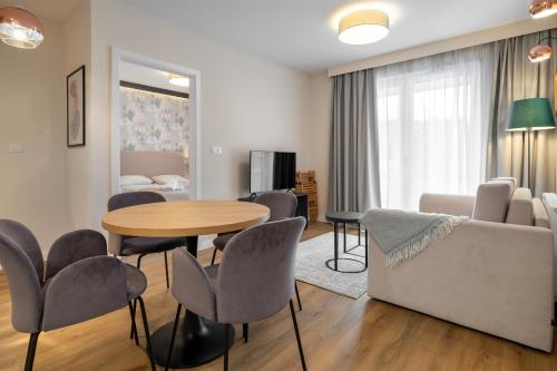 a living room with a table and chairs and a couch at RentPlanet - Apartamenty Zakopiańskie in Zakopane