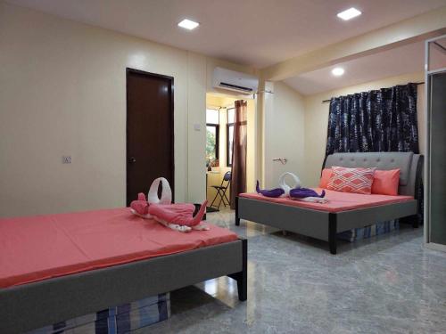 - une chambre avec 2 lits avec des draps roses dans l'établissement T&J Guest House, 