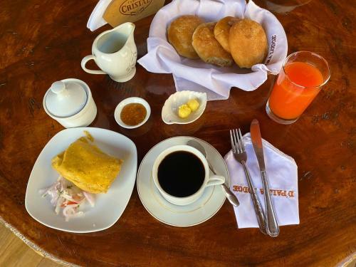 a table with a cup of coffee and a plate of food at Cabañas Palma Sky Lodge in Oxapampa