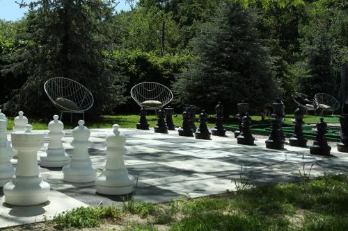 een gigantisch schaakbord en stoelen op een gazon bij Steaua Apelor Family Resort in Nufăru