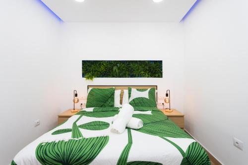 a bedroom with a large bed with green leaves at OkStay Villa Arali Lujo renovado en Tenerife in Fasnia
