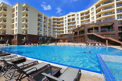 een persoon die zwemt in een zwembad in een hotel bij Golden Sands Rentals Apartments in Goudstrand