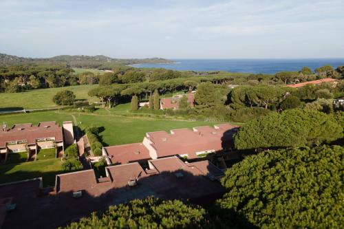 eine Luftansicht eines Hauses mit Bäumen und dem Meer in der Unterkunft Residence Scoglietto 50 in Punta Ala