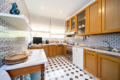 a kitchen with wooden cabinets and a white dishwasher at Residence Scoglietto 50 in Punta Ala