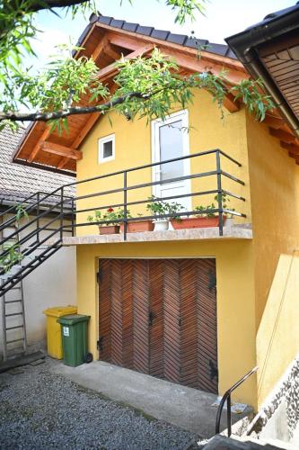 a yellow house with a garage and a balcony at Casa Aron in Sovata